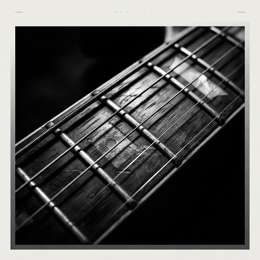 Extreme close-up of a weathered electric guitar fretboard and strings